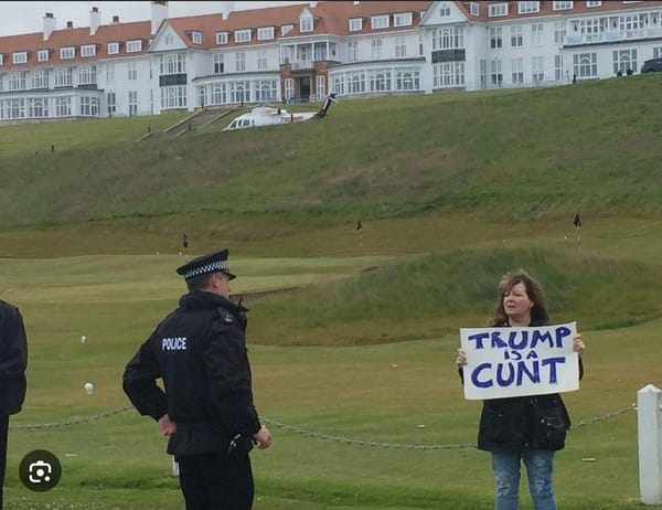 Photo shows Janie Godley at Trump's golf courseholding a sign that reads "Trump is a Cunt."